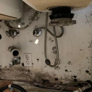 A bathroom sink with a lot of wires coming out of it in Huntington Beach.